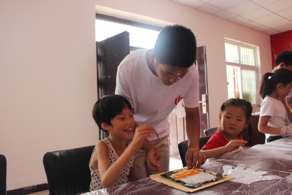 志愿者们和孩子合作制作寿司