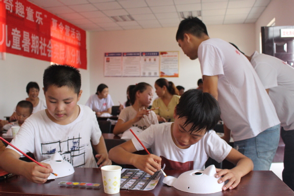 孩子们最喜欢的手工课，志愿者细心地进行指导