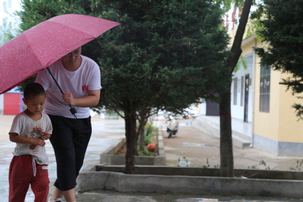 老师在雨中送孩子回家